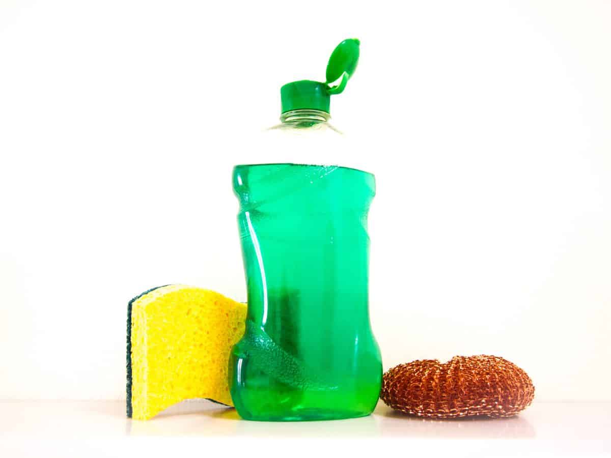 Dish soap in a bottle with a sponge.